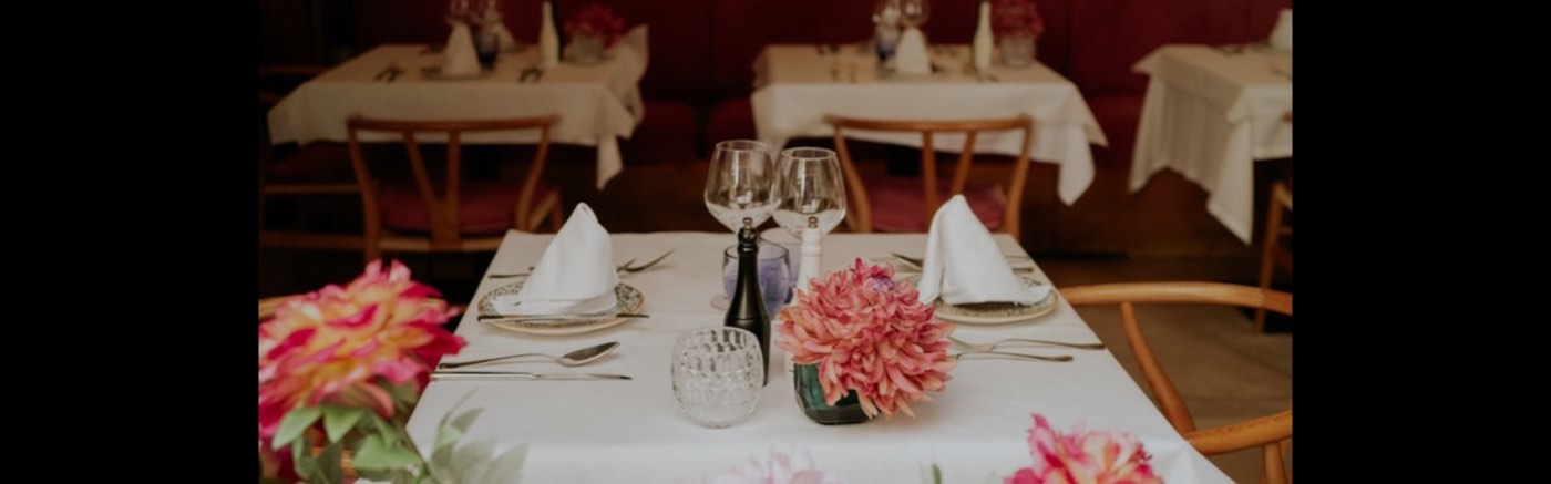 Eingedeckter Tisch mit Gläsern und Blumen