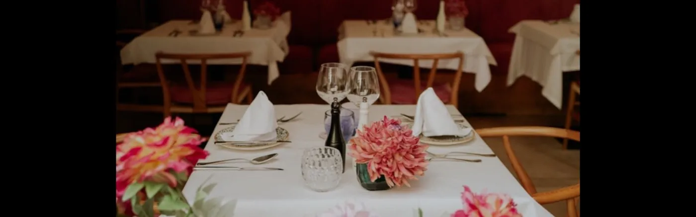 Eingedeckter Tisch mit Gläsern und Blumen