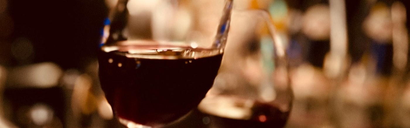 Rotwein wird in ein Glas eingeschenkt