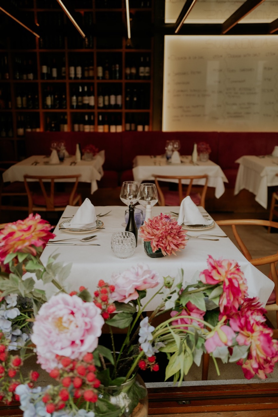 Eingedeckter Tisch mit frischen Blumen im Gastraum